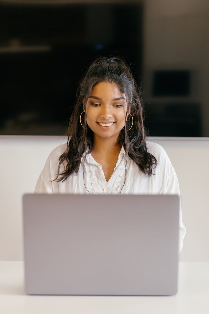 College student smiling while using a laptop